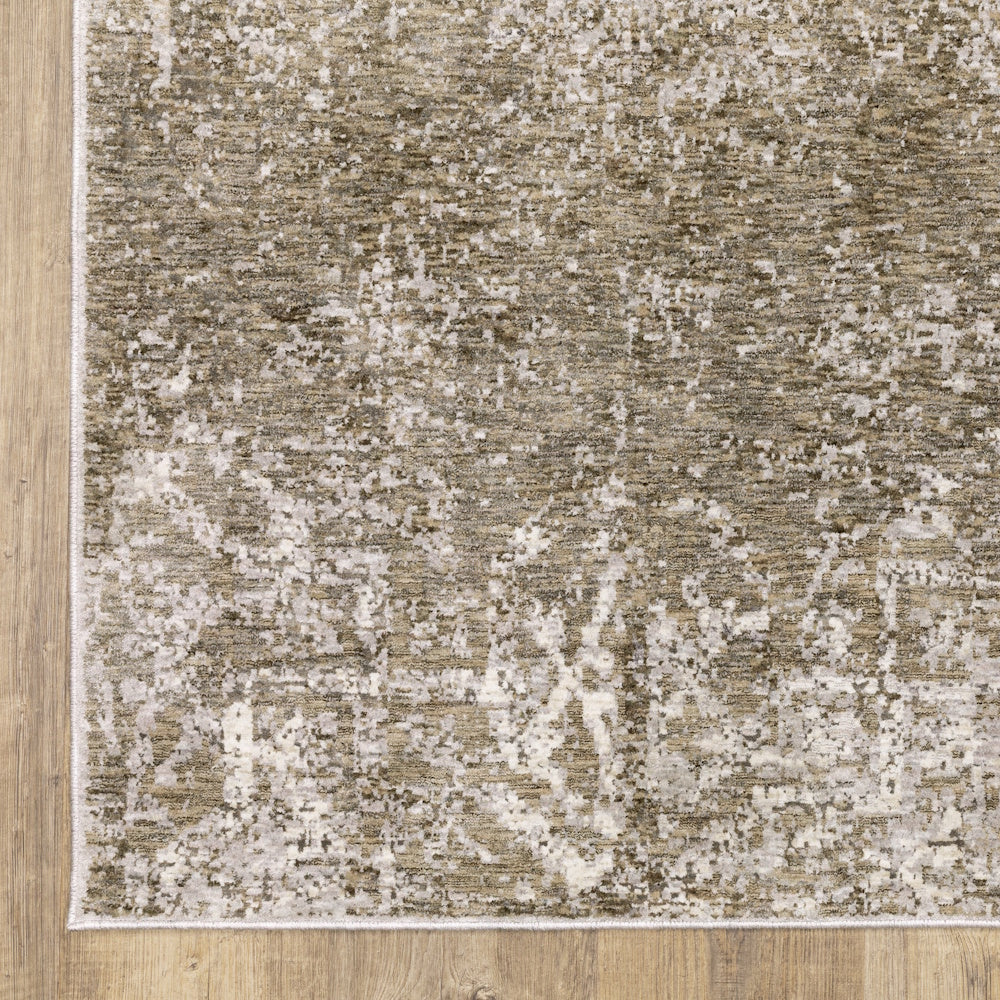 Close-up view of the gray, taupe, and cream area rug showing the edge pattern on a wooden floor.