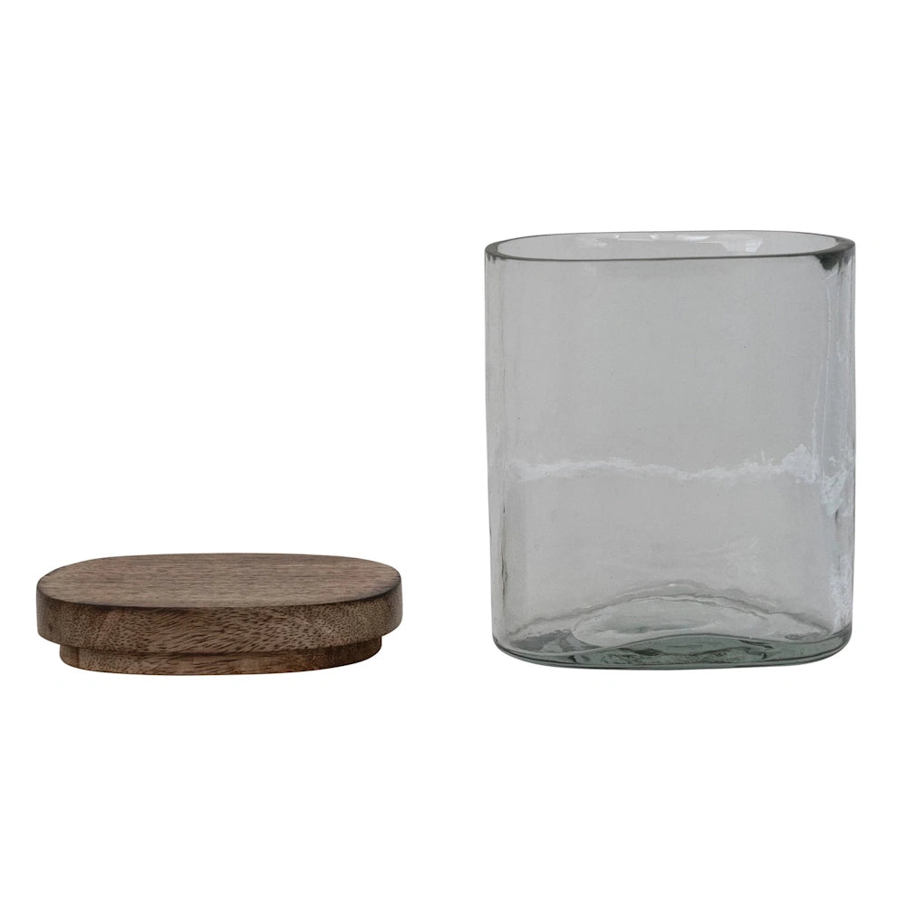 Hand-blown glass storage jar with a removable mango wood lid, minimalist kitchen organization on white background.