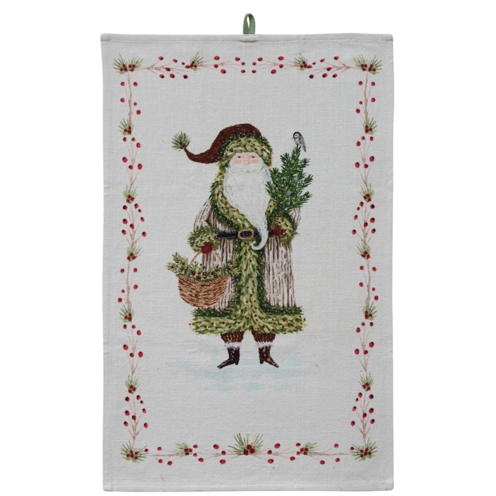 Cotton slub printed Christmas tea towel featuring a Santa design holding a small tree and basket, framed by a festive berry border.