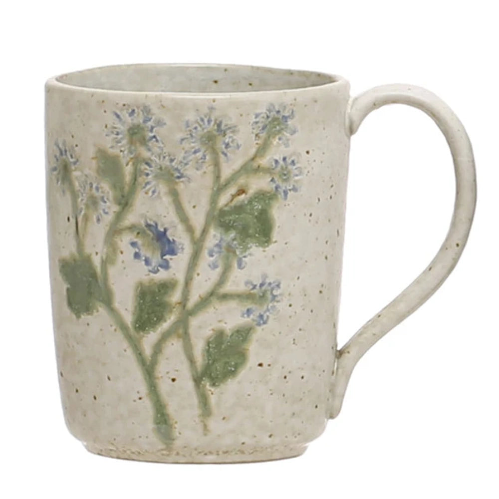 Speckled cream stoneware mug featuring embossed botanical stems with green leaves and blue flowers.