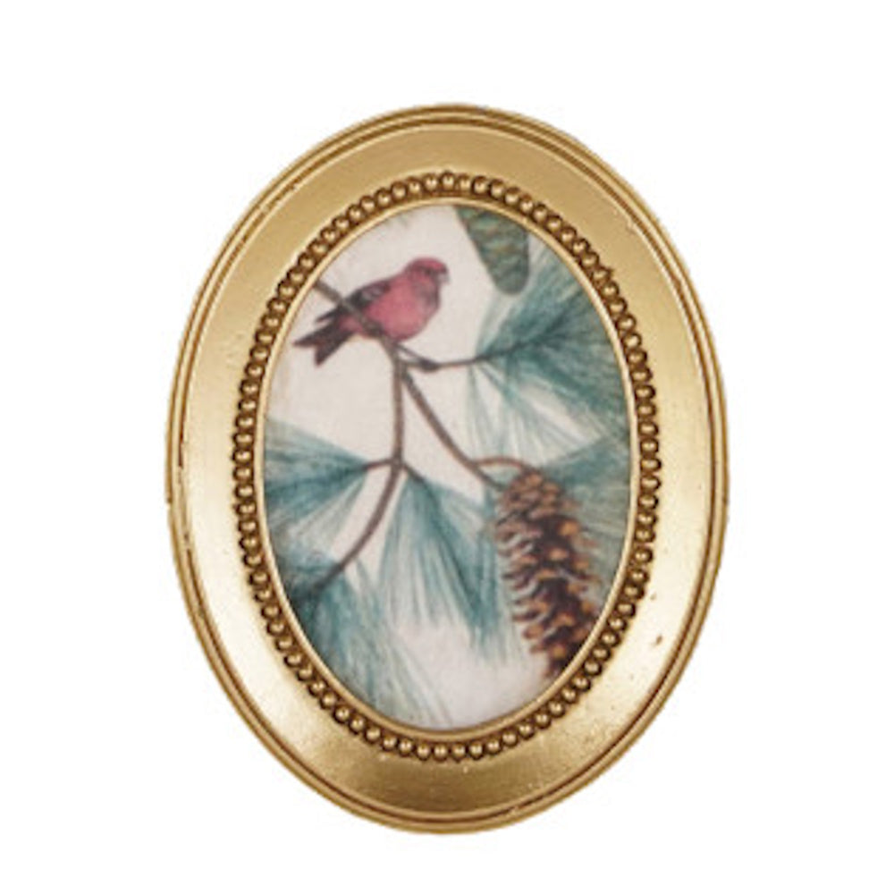 Vintage oval gold frame showcasing artwork of a pink bird perched on a pine branch with pinecones.