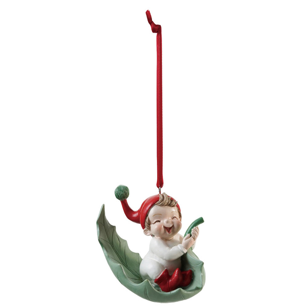 Resin elf ornament resting in a green leaf-shaped cradle with a red ribbon.