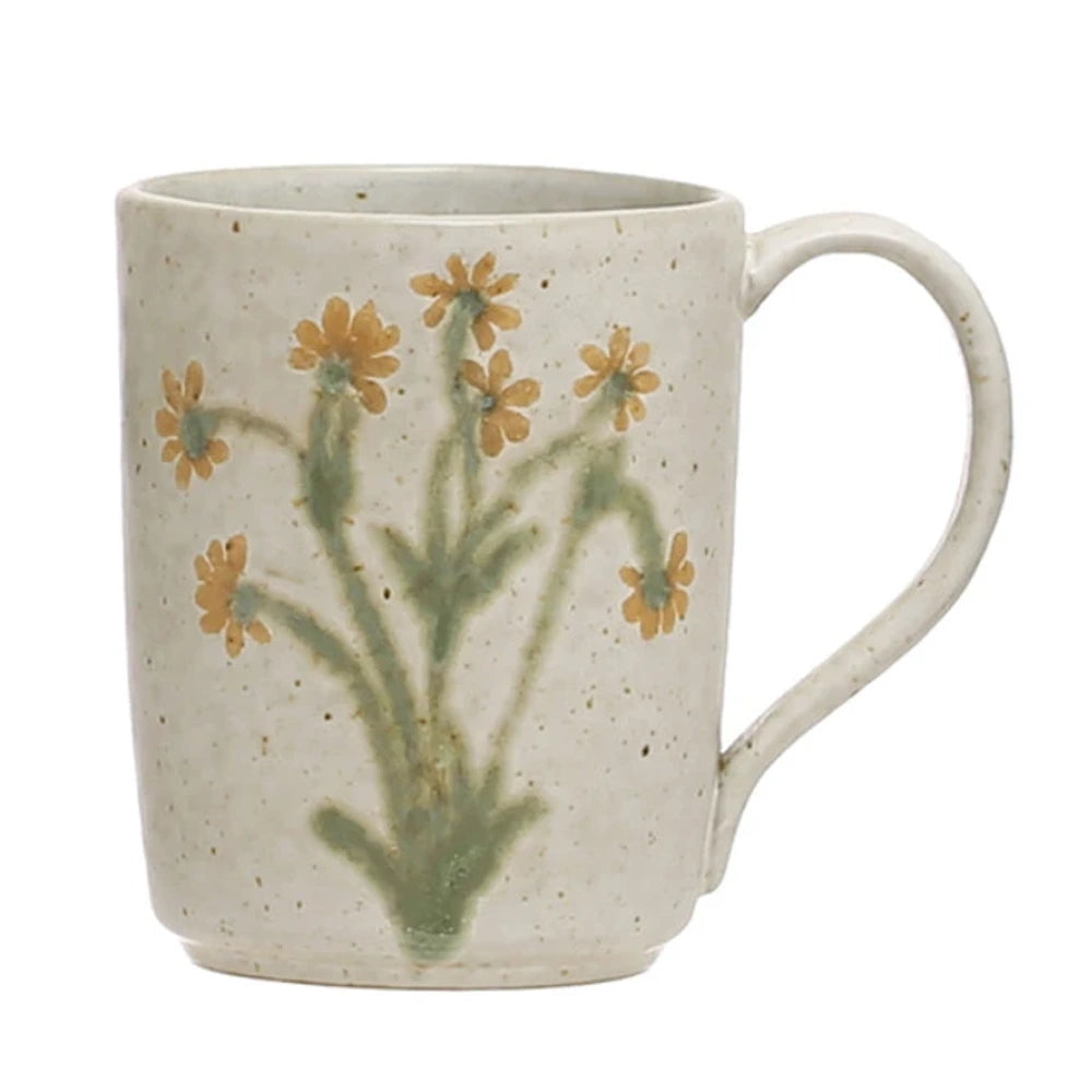 Speckled cream stoneware mug featuring embossed botanical stems with green leaves and yellow flowers.