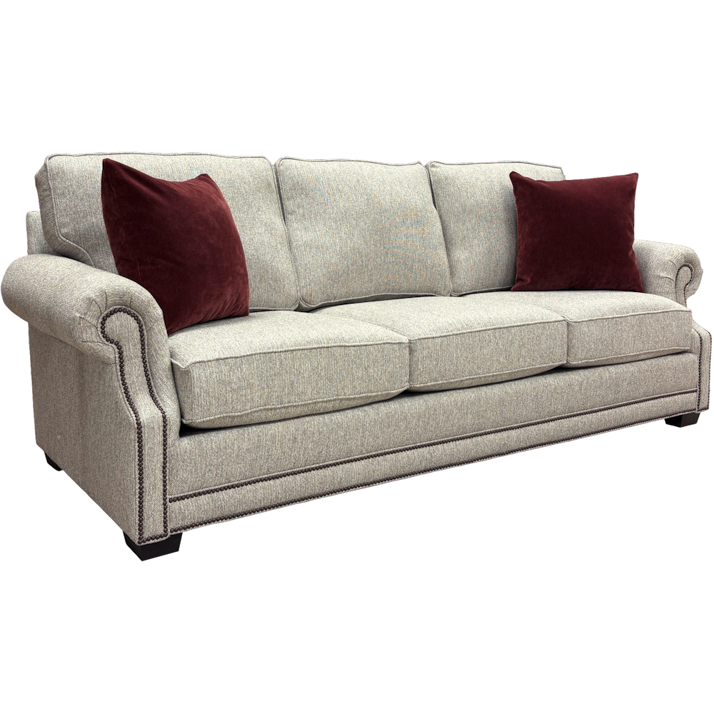 Light grey tweed sofa with rolled arms, nailhead trim, and dark red pillows against a white background.