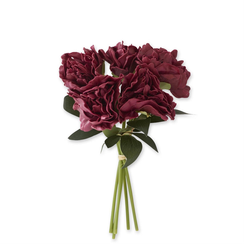 Bundle of artificial burgundy peonies tied together at the green stems with raffia.