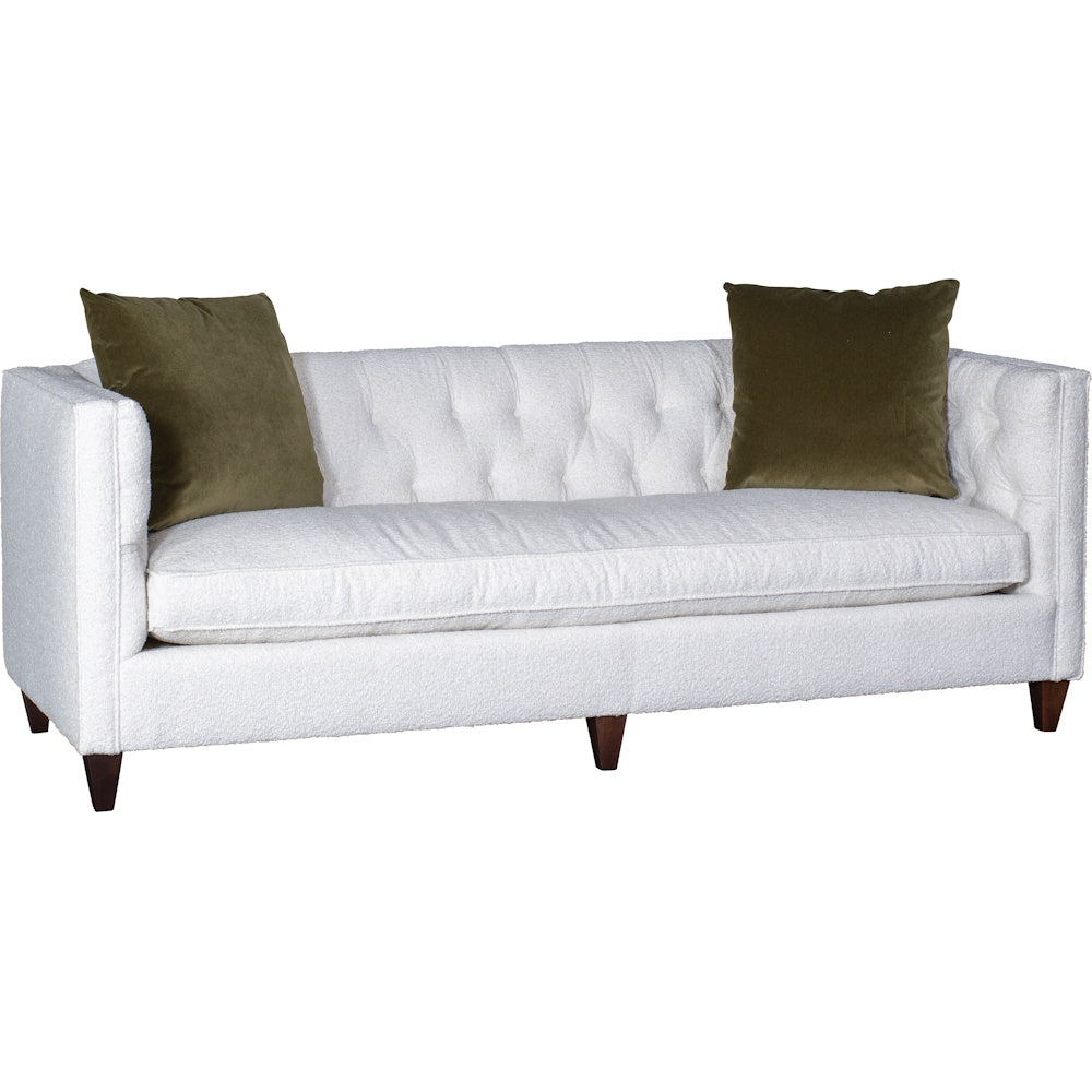 White bouclé sofa with tufted backrest, plush seat cushion, olive accent pillows and tapered wood legs.