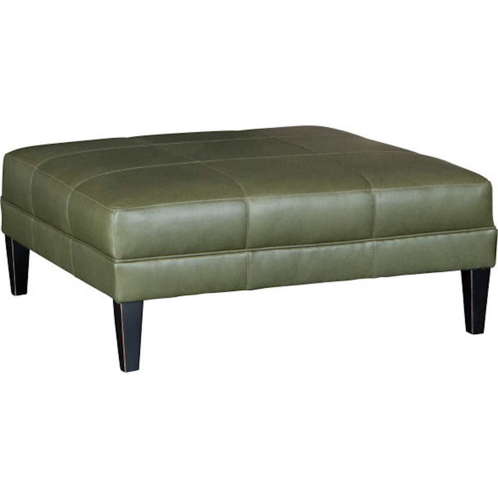 Olive green leather square ottoman with grid stitching and dark tapered legs on a white background.