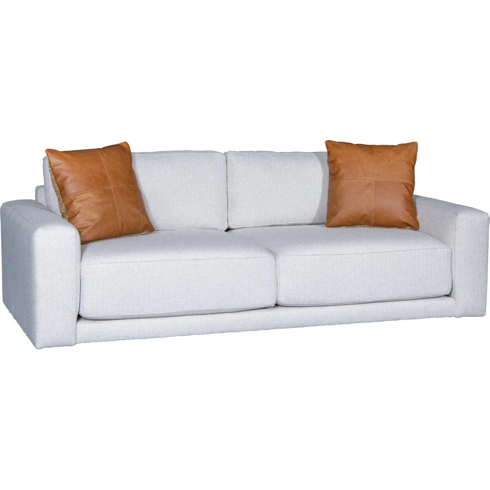 Off-white upholstered sofa with brown leather accent pillows on a white background.