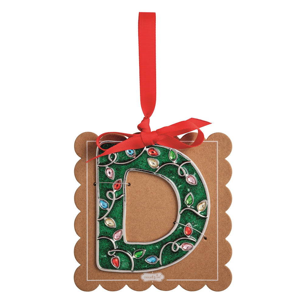 Sparkly green Christmas initial ornament letter D on a scalloped brown card with a red hanging ribbon.
