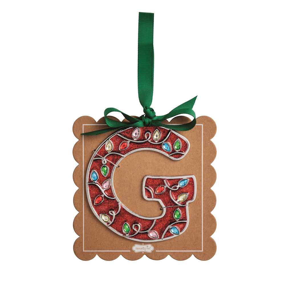 Sparkly red Christmas initial ornament letter G mounted on a scalloped brown card with a green hanging ribbon.