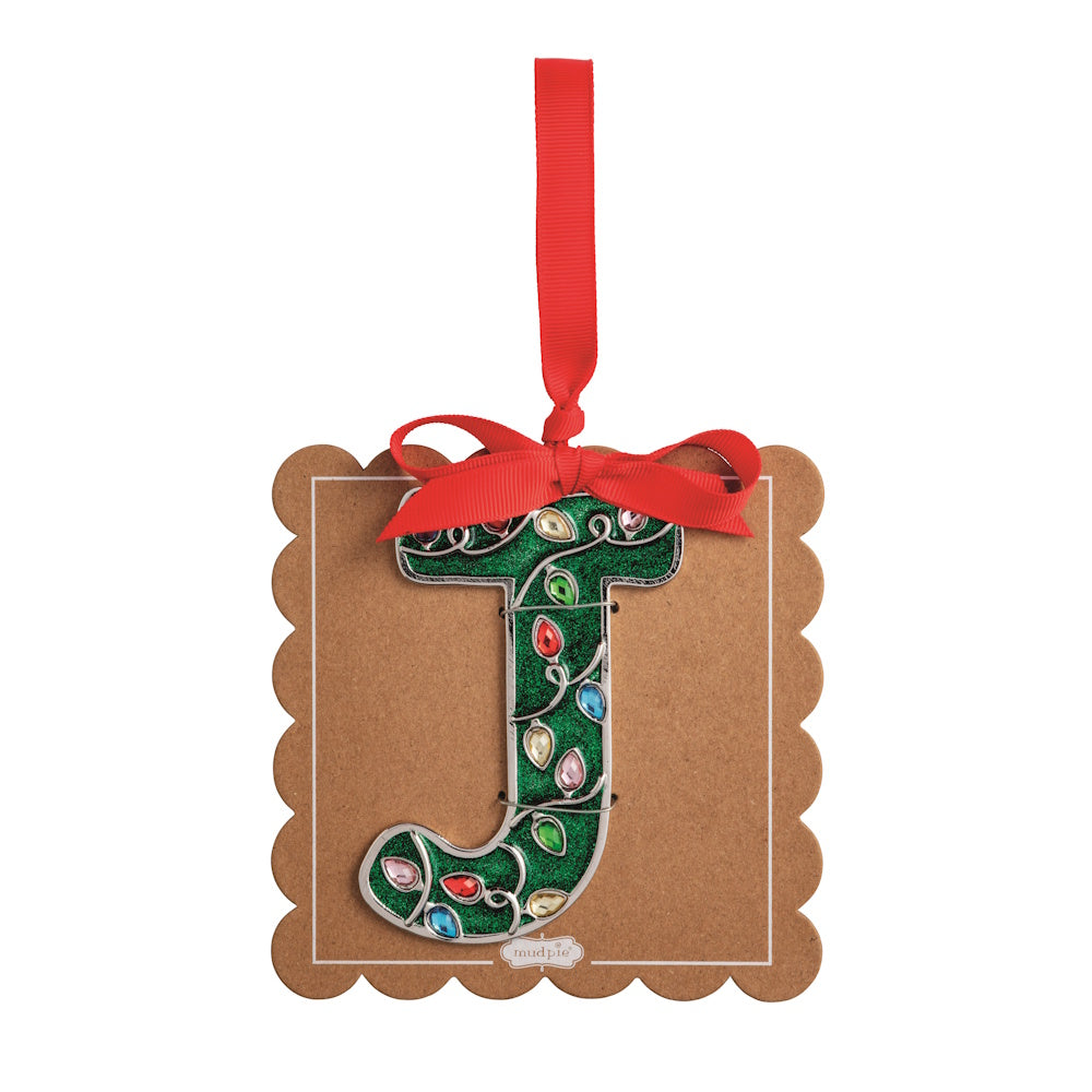 Sparkly green Christmas initial ornament letter J on a scalloped brown card with a red hanging ribbon.