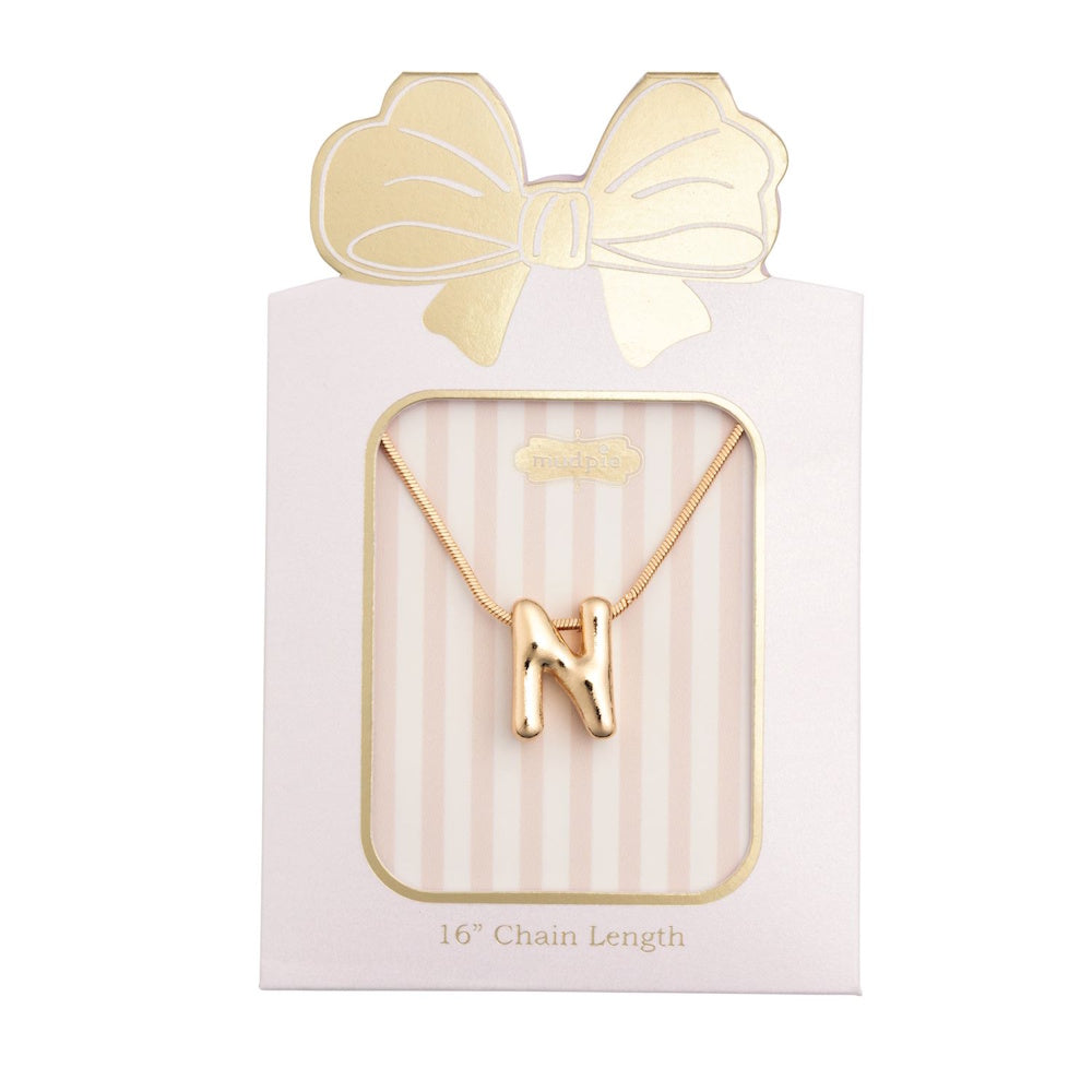 Gold initial "N" pendant necklace packaged in a pink box with a gold bow design.