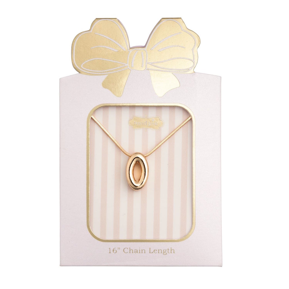 Gold initial "O" pendant necklace packaged in a pink box with a gold bow design.
