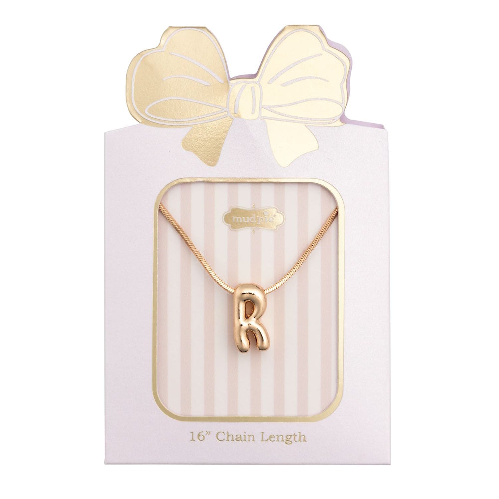 Gold initial "R" pendant necklace packaged in a pink box with a gold bow design.