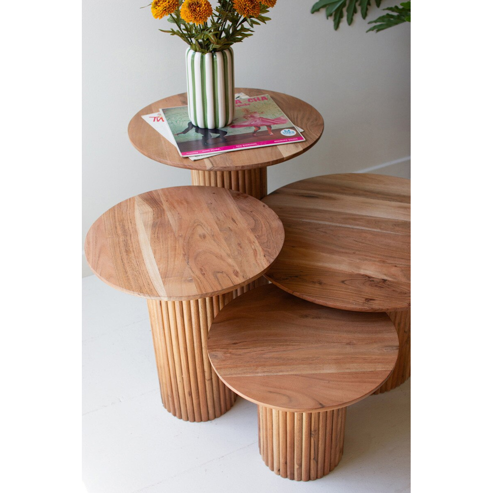 High-angle view of nested round acacia wood accent tables with ribbed bases and smooth tops.