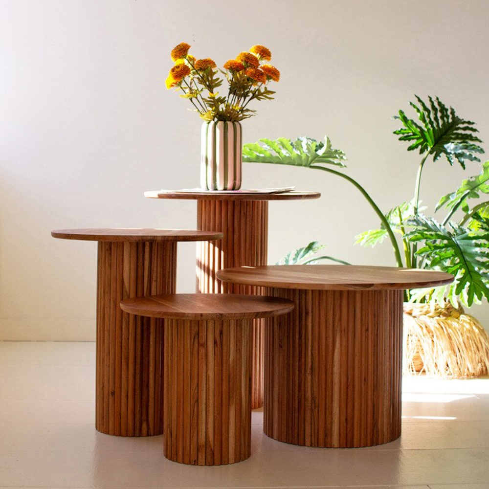 Acacia wood accent tables with ribbed tambour bases in various sizes displayed together in a room.
