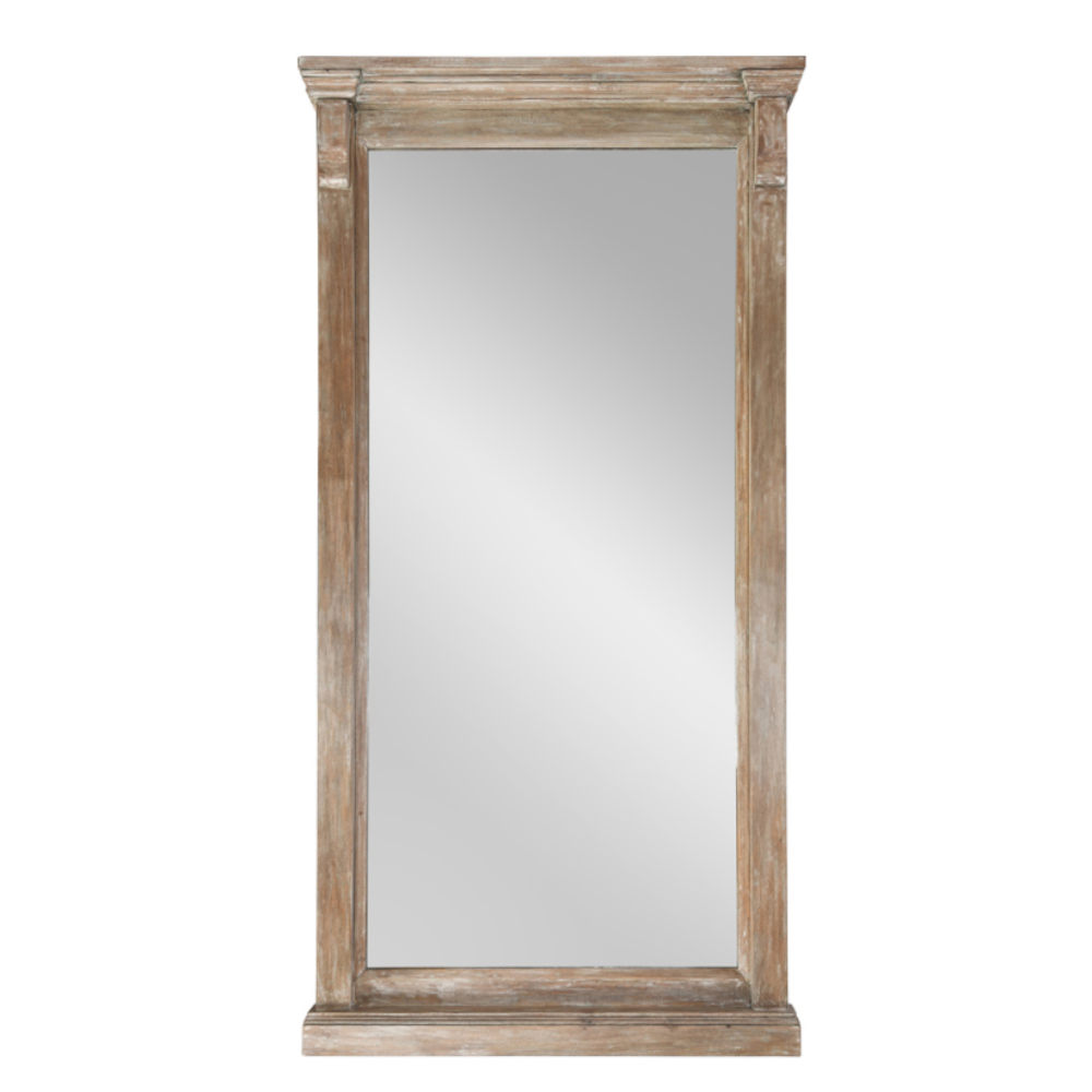 Tall floor-standing mirror framed in weathered light brown wood with molded details.