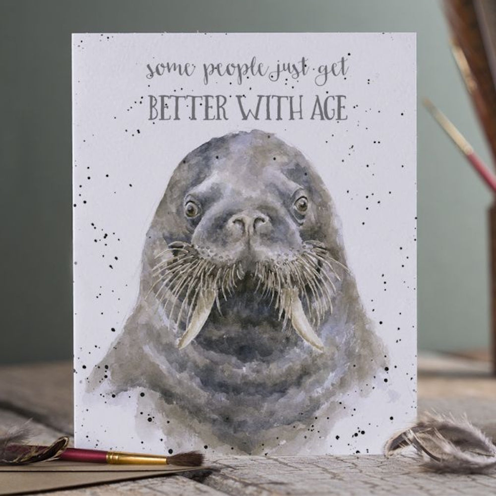 Watercolor walrus birthday card featuring the text "some people just get BETTER WITH AGE" on a speckled white background.