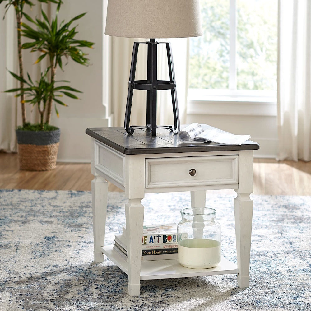Two-tone square end table with one drawer, bottom shelf, and dark top in a living room setting.