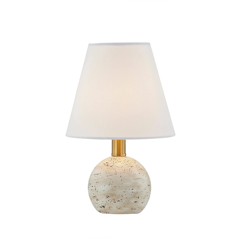 Small table lamp with a white tapered shade, gold neck, and a speckled beige stone sphere base on a white background.