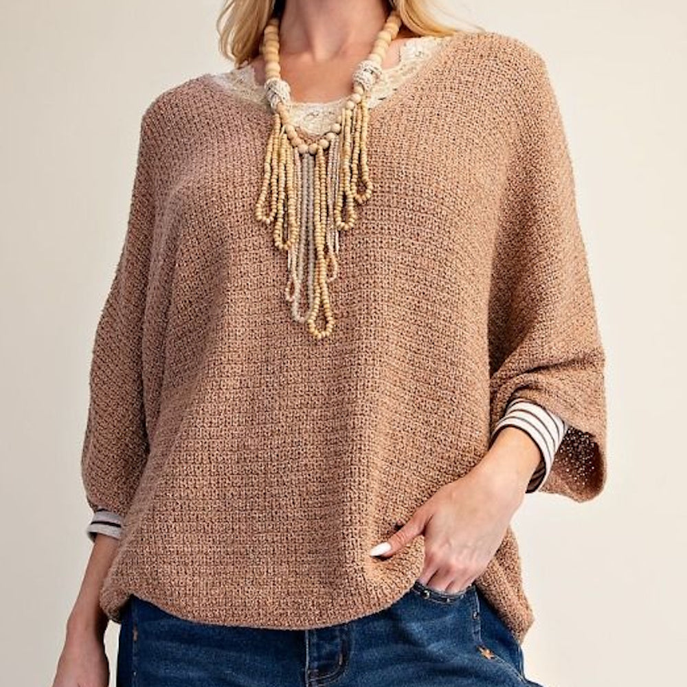 Almond textured knit sweater featuring wide 3/4 sleeves, layered over lace trim with a beaded necklace.