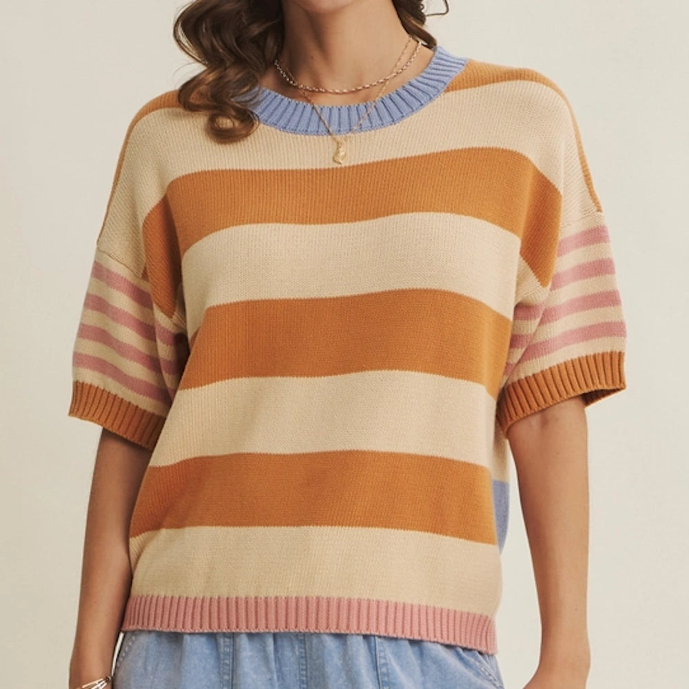 Short-sleeved sweater with orange, cream, and pink horizontal stripes, a blue collar, and pink ribbed hem.