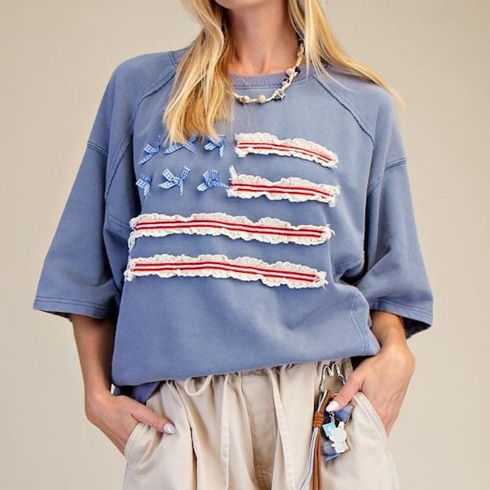 Oversized blue sweatshirt with American flag design featuring gingham bows and red lace stripes.