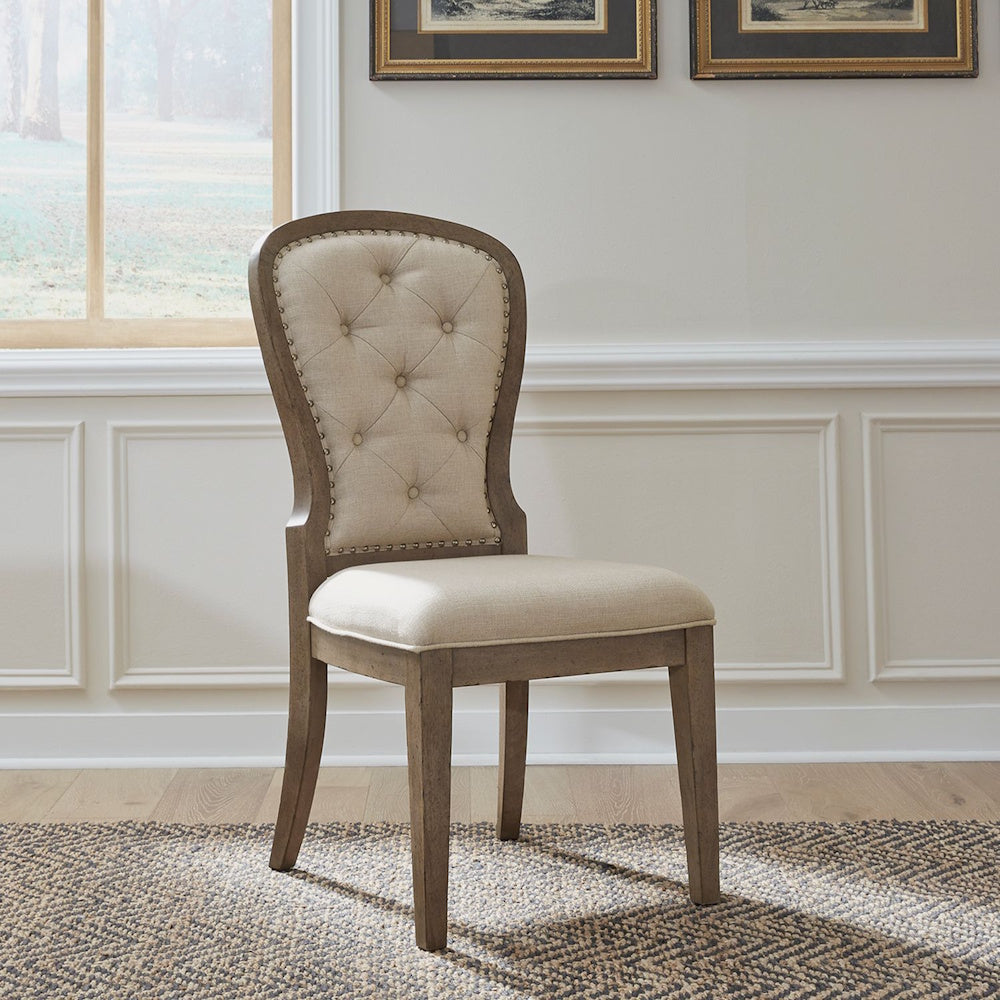 Americana farmhouse upholstered tufted back side chair in a bright dining room setting.