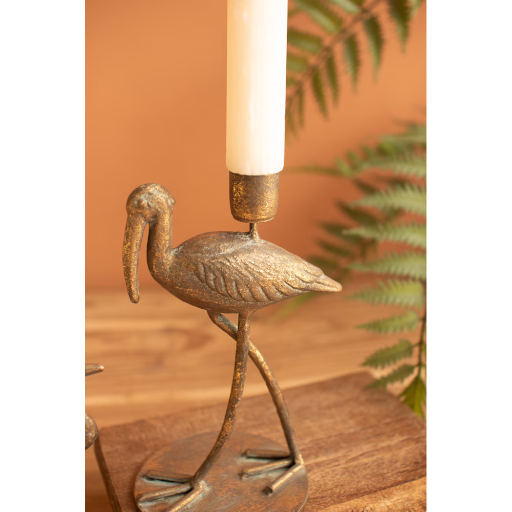 Close-up view of the taller antique brass shorebird taper candleholder with a white candle.