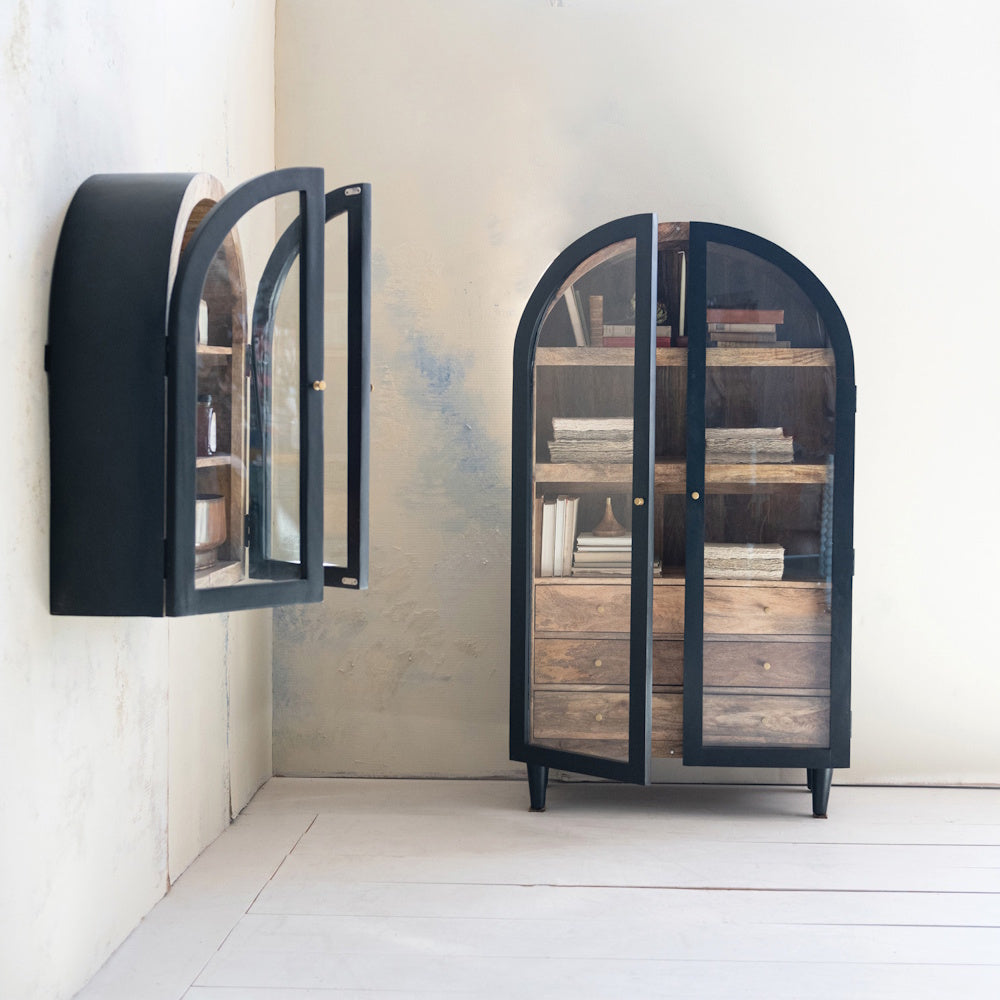Black arched mango wood cabinets in floor-standing and wall-mounted styles with glass doors and internal shelving.