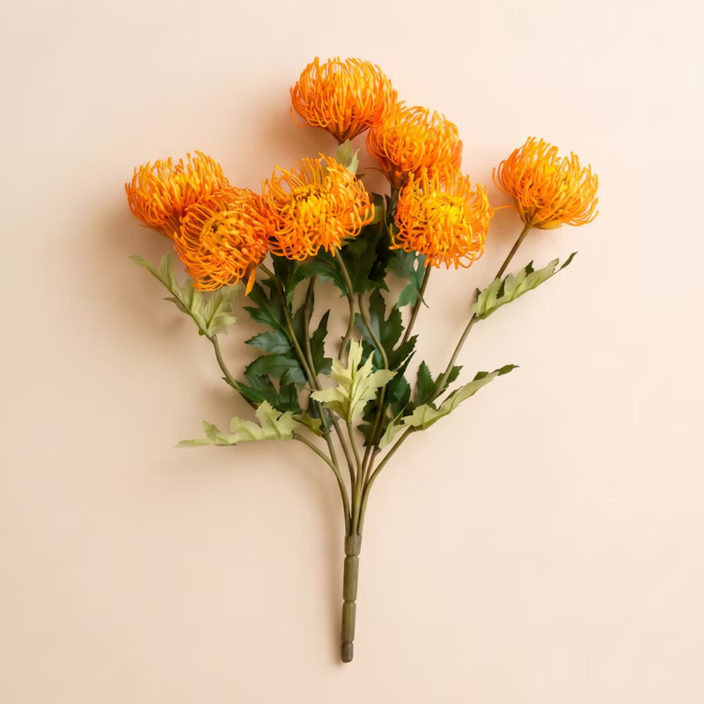 Bright orange pincushion protea artificial floral stem set on a smooth beige background.