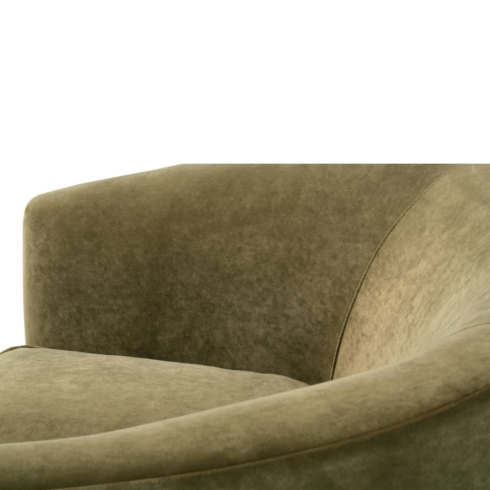 Close-up view of the smooth, curved armrest and plush seat cushion of an olive green velvet chair.