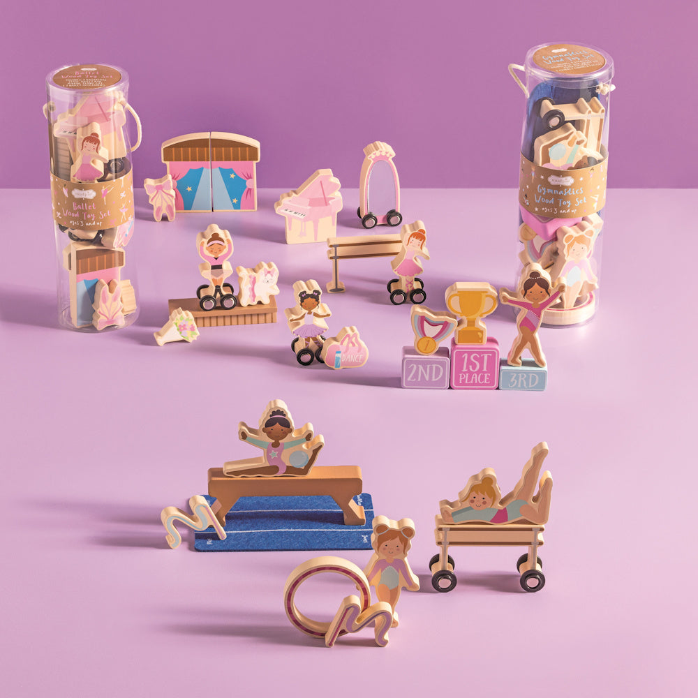 Wooden ballet and gymnastics toy set featuring diverse figures, balance beam, piano, and trophies on a purple background.