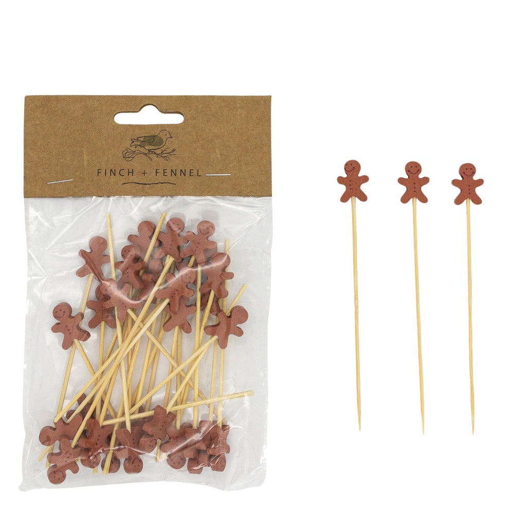 Packaged wooden appetizer picks topped with brown gingerbread man cutouts next to three individual picks.