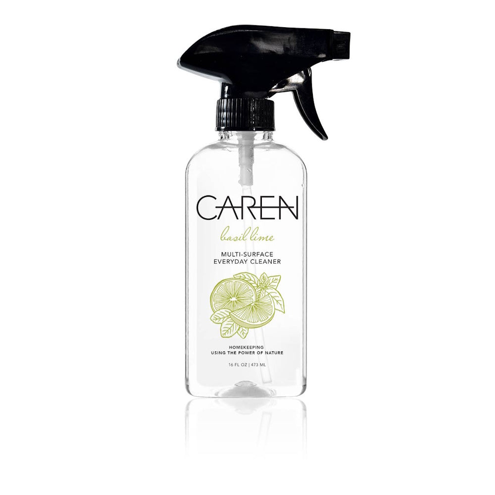 Clear spray bottle of "Caren" Basil Lime Multi-Surface Cleaner with a black nozzle and green citrus graphics.