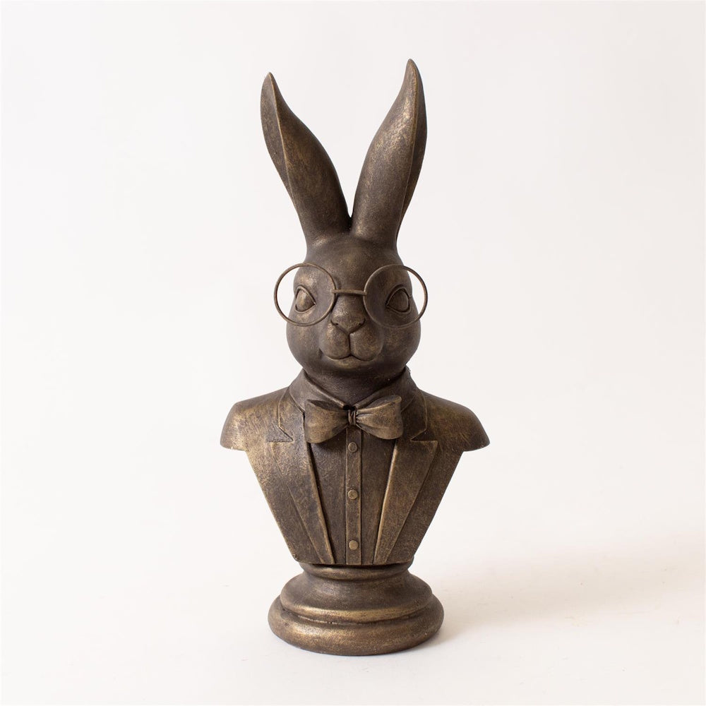 Bronze bust of a rabbit wearing round glasses, a suit, and a bowtie against a white background.