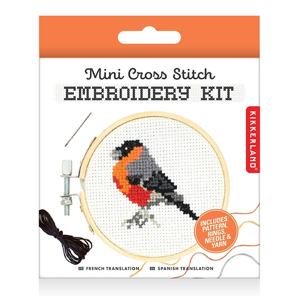 Kikkerland mini cross stitch embroidery kit featuring a bullfinch bird design in a wooden hoop with needle and thread.