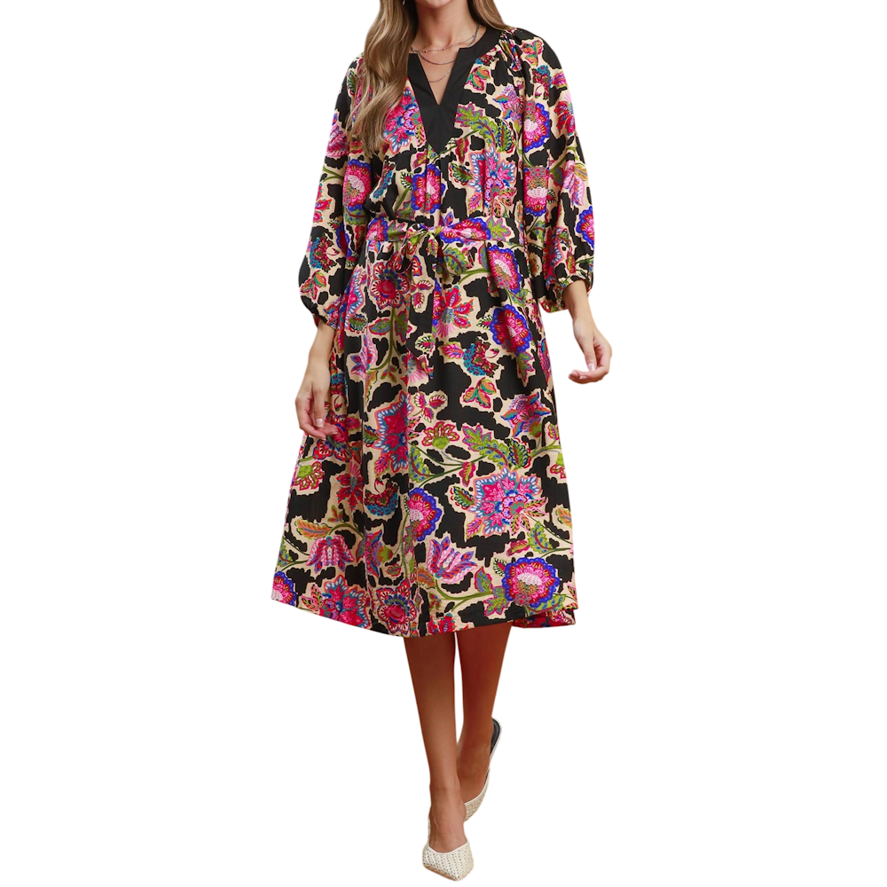 Woman wearing a colorful abstract floral print midi dress with a V-neckline and tied waist belt.