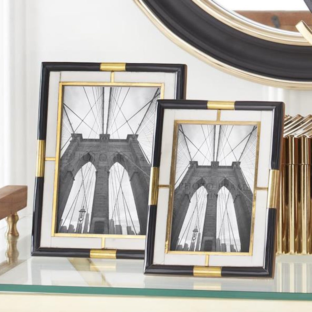 Modern black and white marble photo frames with gold accents displaying Brooklyn Bridge architectural prints.