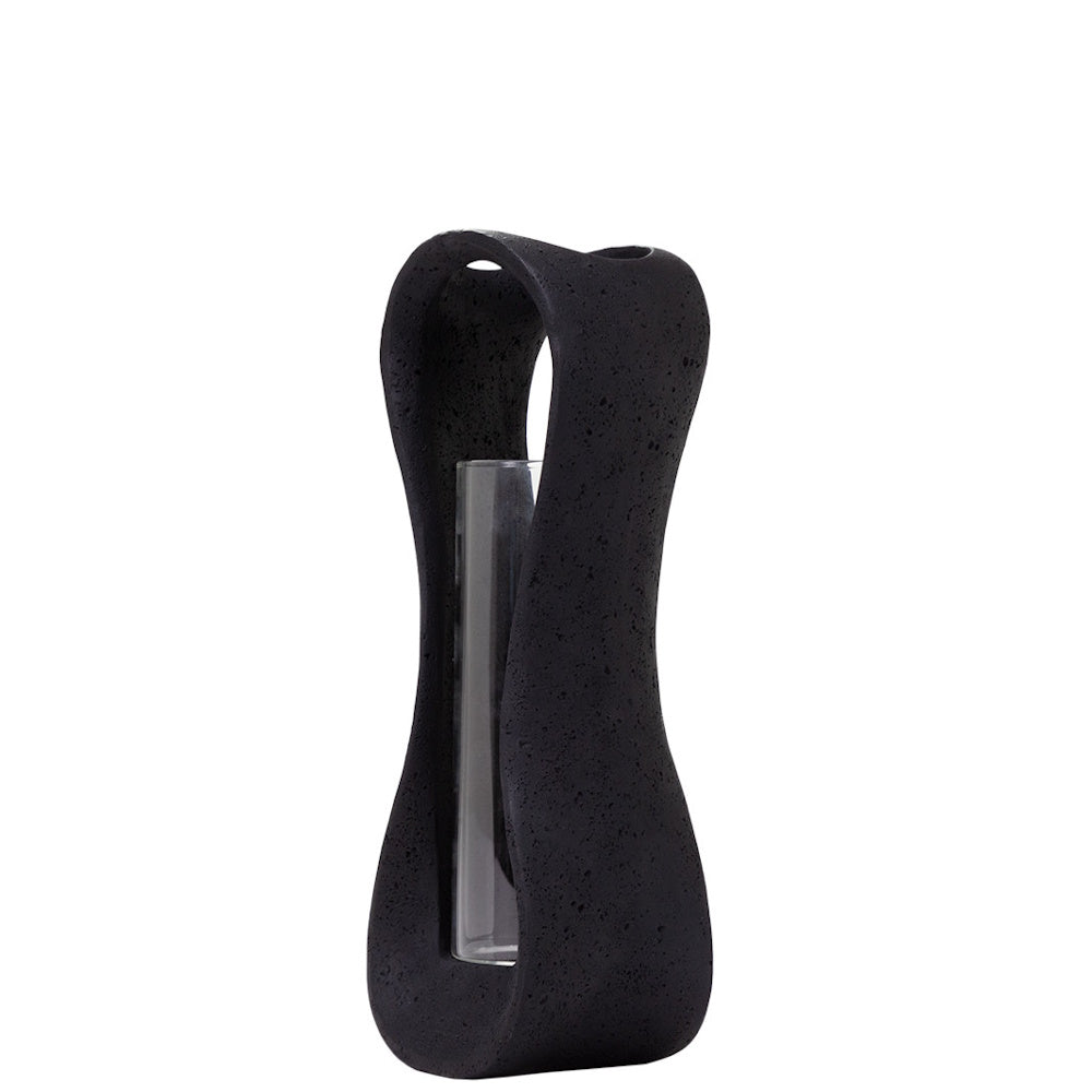 Modern black lava stone hurricane candle holder with a clear glass insert, featuring a unique sculptural hourglass shape.