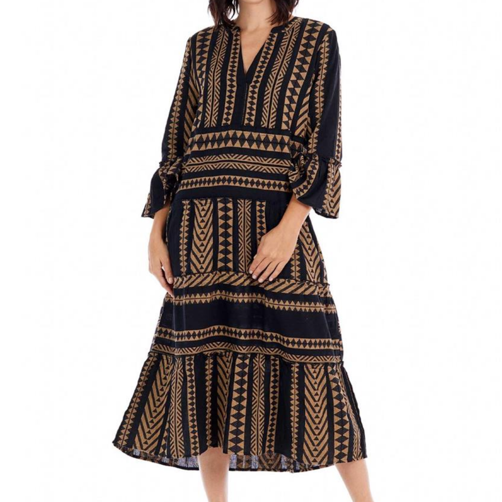 Woman wearing a black midi dress with a tan geometric tribal print, V-neck, and tiered skirt.