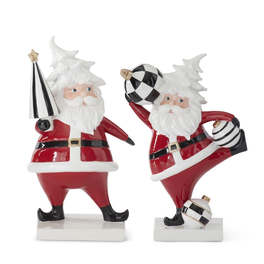 Set of 2 whimsical resin Santa figurines in red suits with black-and-white accents, holding striped and checkered ornaments.