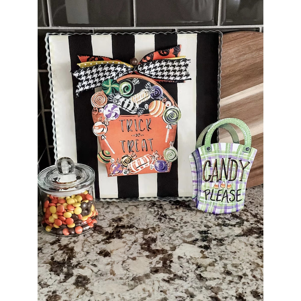 Halloween Trick or Treat display board with a candy jar and Candy Please sign on a granite countertop.