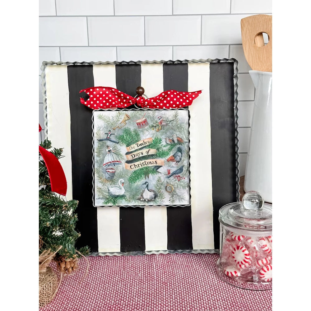 Twelve Days of Christmas display board with a red polka dot bow and peppermint candy jar table decor.