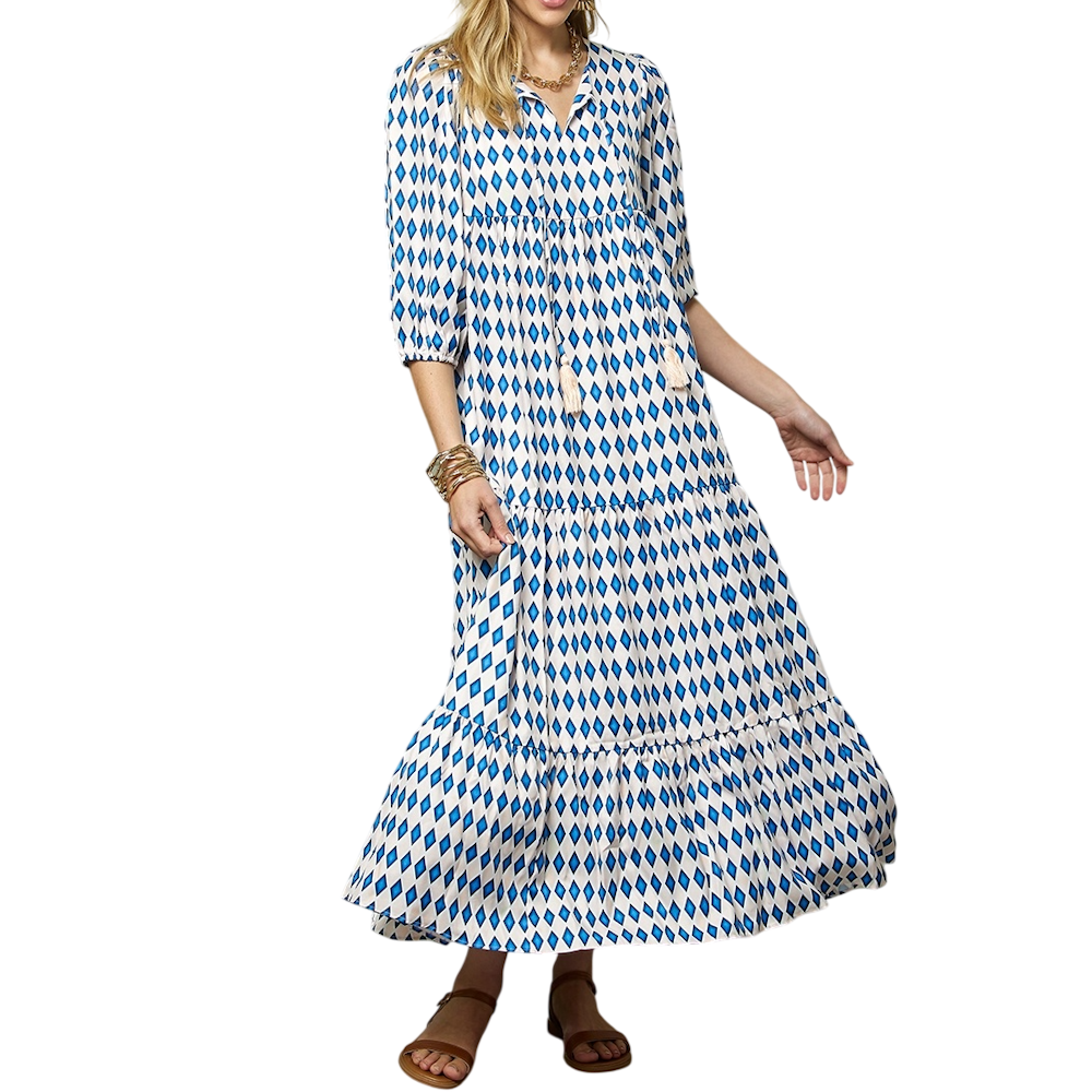 A woman wearing a tiered maxi dress with a blue and white diamond pattern and three-quarter puff sleeves.