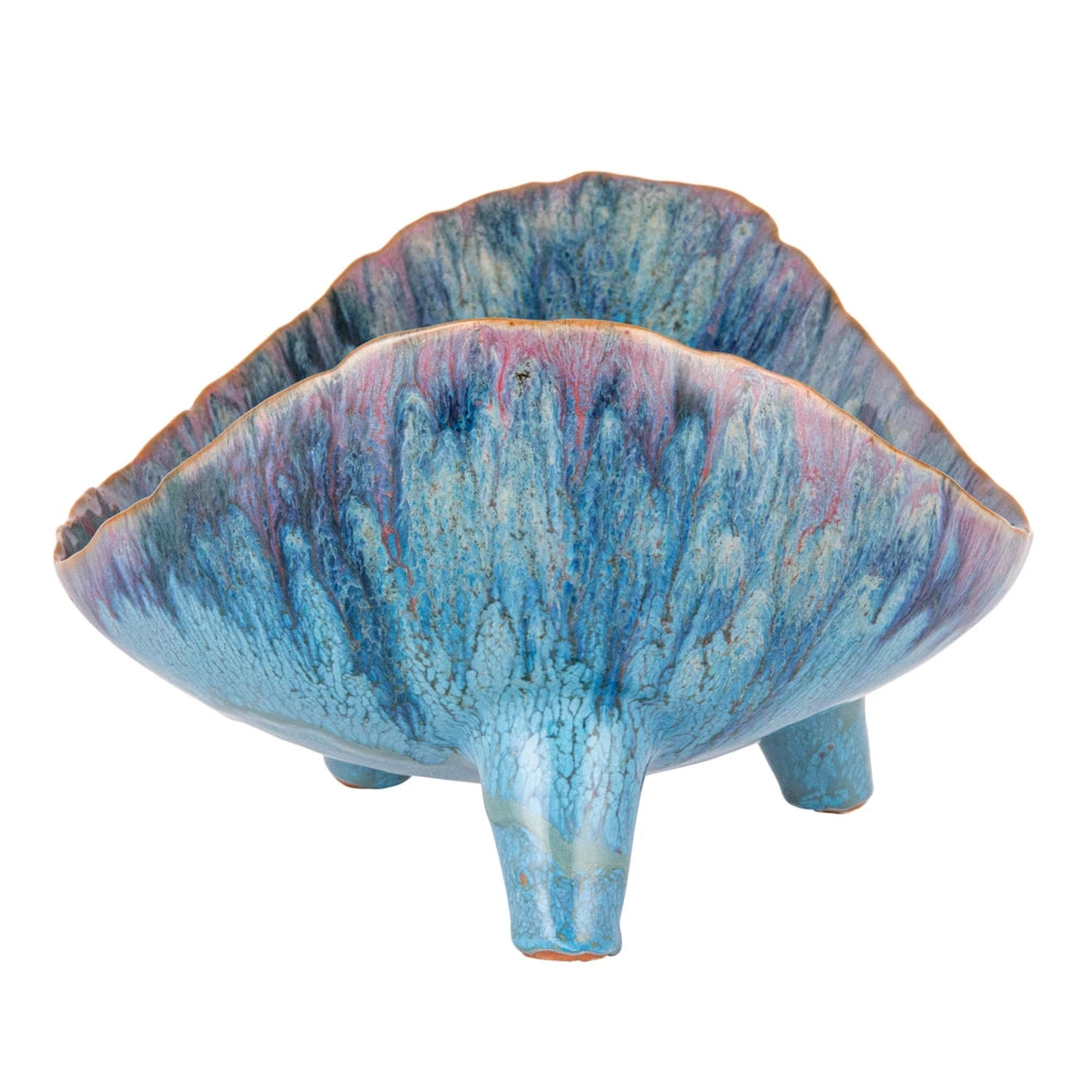 Blue and purple organic-shaped stoneware footed bowl with a textured reactive glaze on a white background.