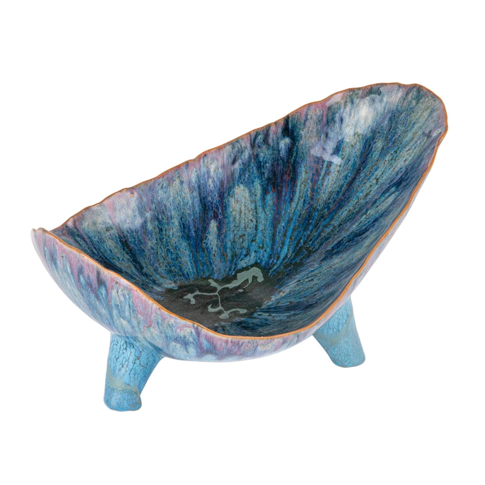 Blue stoneware footed organic-shaped bowl with a reactive drip glaze in shades of deep blue, purple, and turquoise.