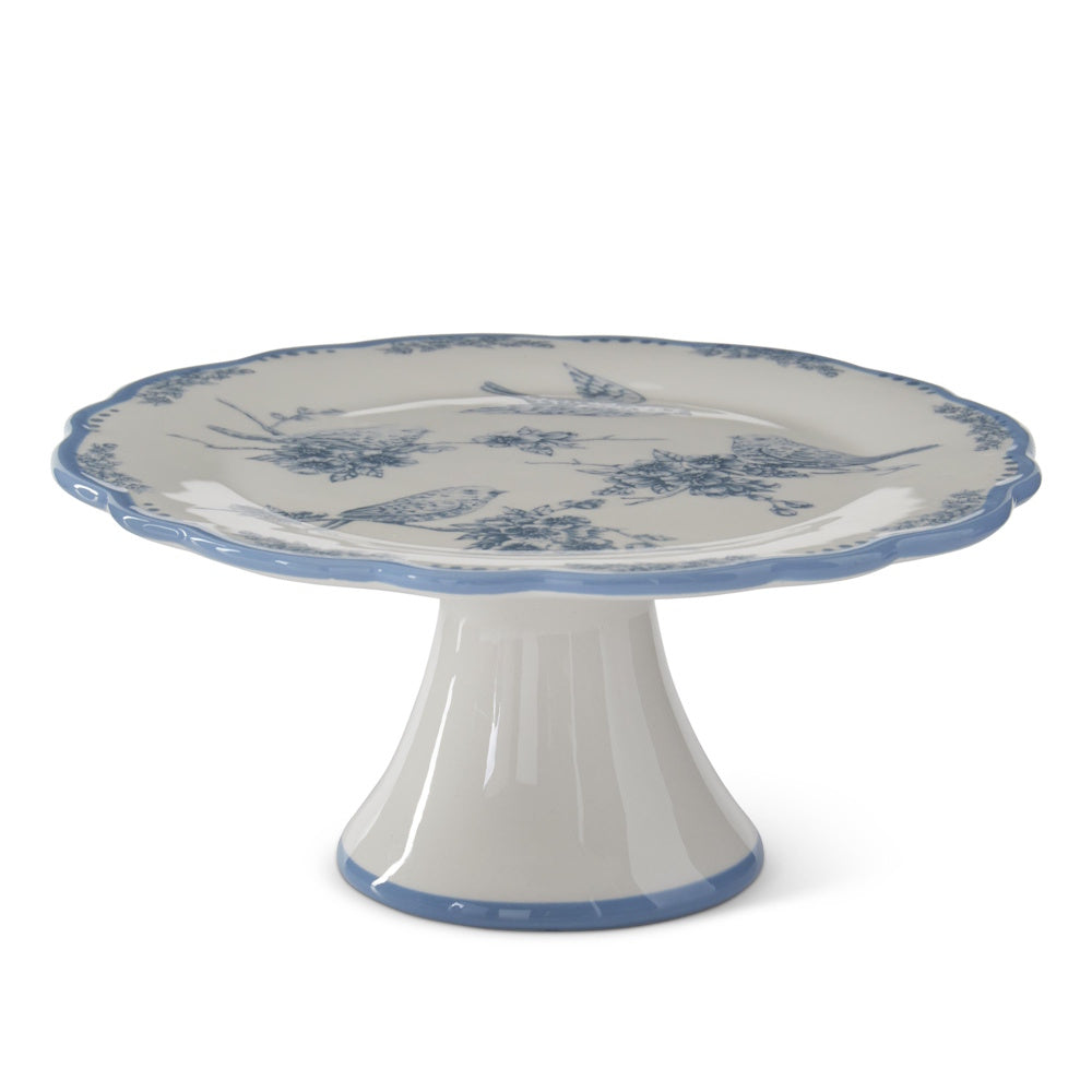 White and blue dolomite cake stand with floral and bird patterns and a scalloped rim.