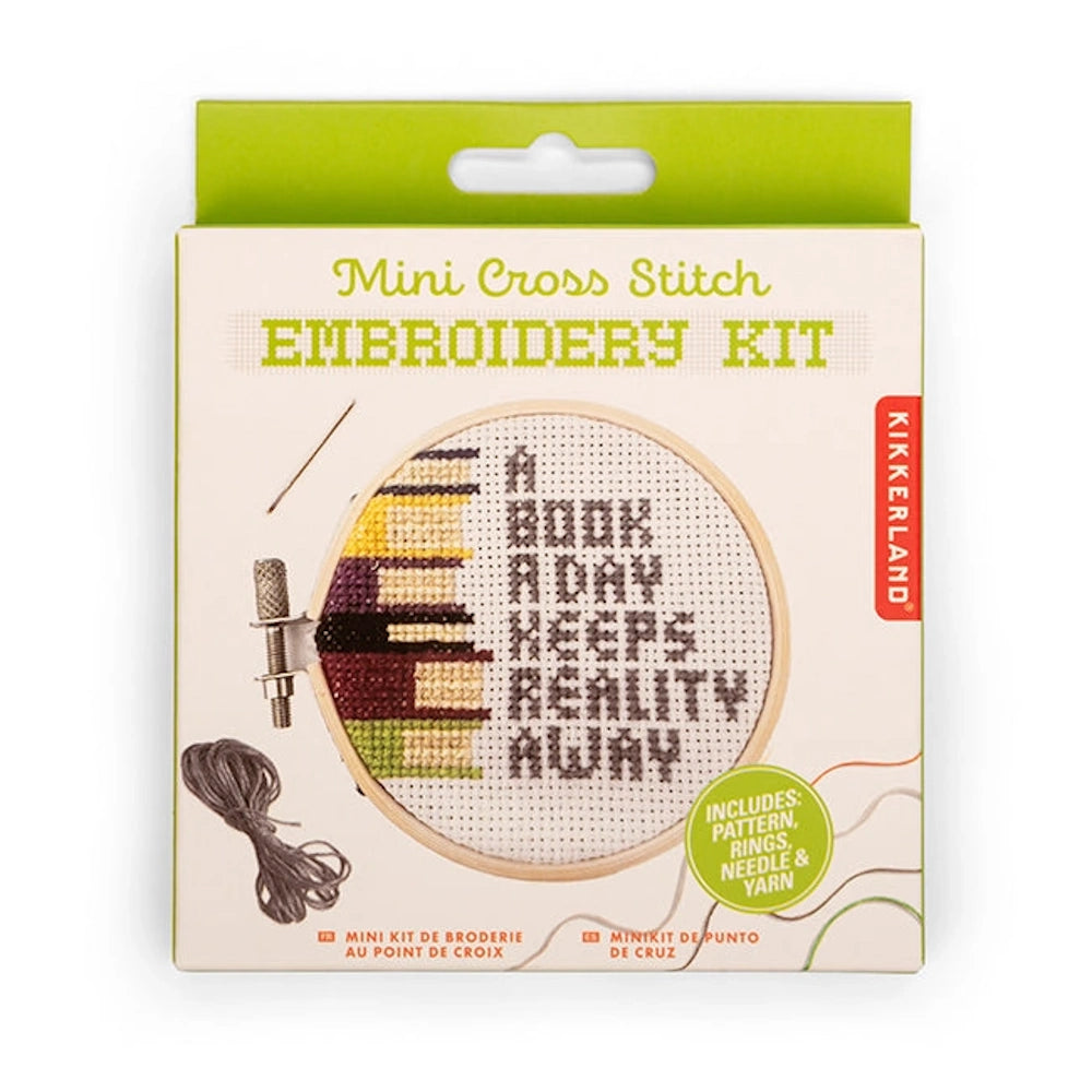 Kikkerland Mini Cross Stitch Embroidery Kit featuring a stack of books and "A book a day keeps reality away" text.