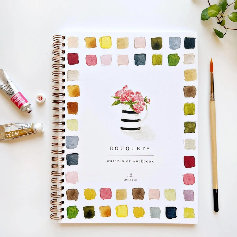 Watercolor workbook titled "Bouquets" by Emily Lex, surrounded by paint swatches, tubes, and a paintbrush.